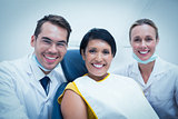Portrait of smiling dentist and assistant with female patient