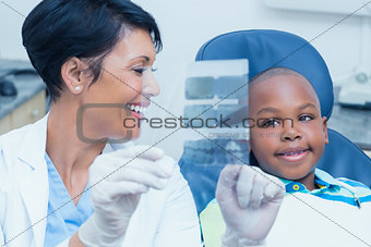 Female dentist showing boy his mouth x-ray