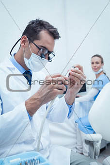 Concentrated dentist looking at dental tool