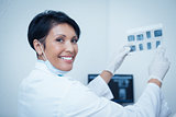 Smiling female dentist holding x-ray