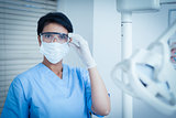 Dentist wearing surgical mask and safety glasses