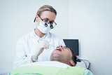 Female dentist examining mans teeth