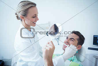 Female dentist brushing mans teeth