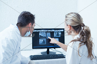 Dentists looking at x-ray on computer