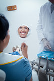 Smiling young woman looking at mirror