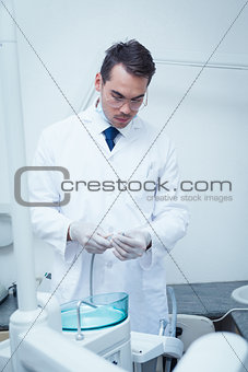 Male dentist holding dental drill