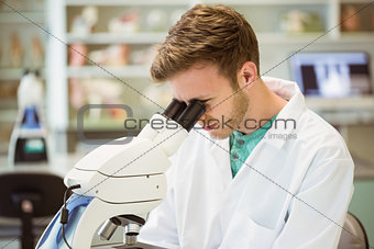 Young scientist looking through microscope