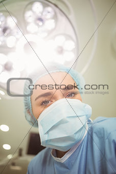 Young surgeon looking down at camera
