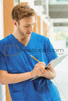 Medical student taking notes in hallway