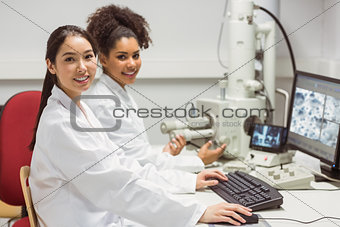 Science students working with microscopic image on computer