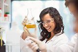 Pretty science student smiling and holding beaker
