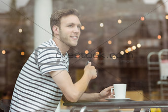 Smiling student sitting with a hot drink