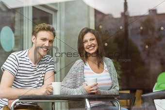 Smiling friends holding mug of coffee