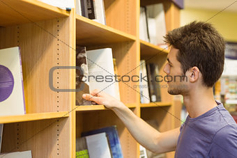 University student choosing books on bookshelves
