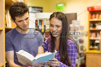 Smiling friends student reading textbook