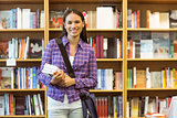Smiling university student holding textbook
