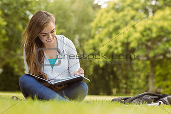 Smiling student sitting and reading book