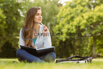 Thinking student sitting and holding book