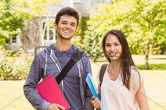 Smiling friends student standing with shoulder bag holding book