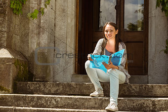 Smiling student sitting and holding book