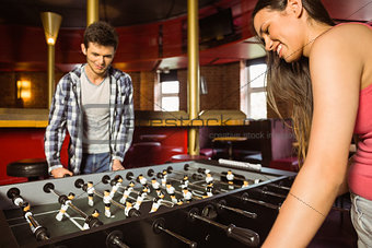 Smiling friends playing table football