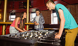 Smiling friends student playing table football in competition