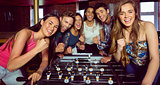 Portrait of happy friends playing table football