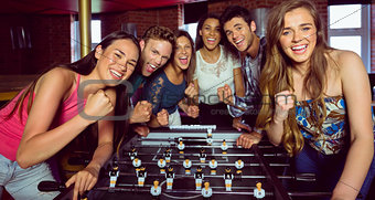 Portrait of happy friends playing table football