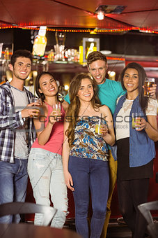 Smiling friends drinking beer and mixed drink
