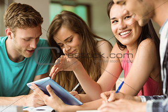 Smiling friends sitting using tablet pc