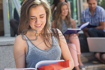 Pretty student reading from notepad