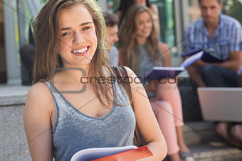 Pretty student smiling at camera outside