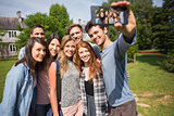 Happy students taking a selfie outside on campus
