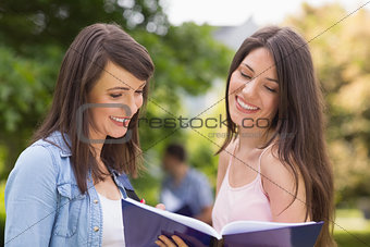 Pretty students reading from notepad