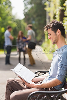 Handsome student studying outside on campus
