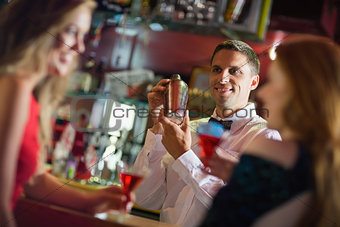 Handsome barman chatting to customers