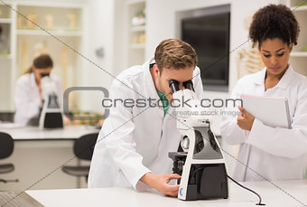 Medical students working with microscope
