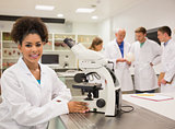 Happy medical student working with microscope