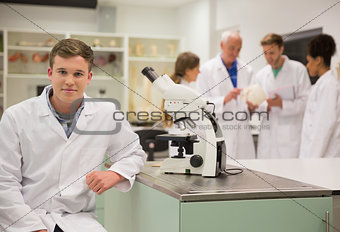 Happy medical student working with microscope