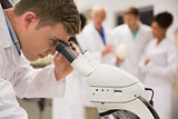 Young medical student working with microscope
