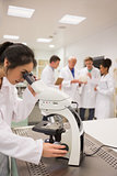Young medical student working with microscope