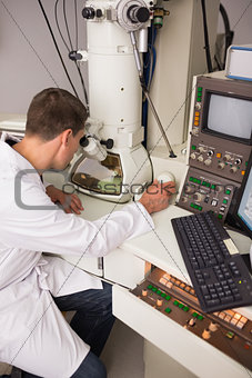 Biochemistry student using large microscope and computer