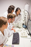 Biochemistry students using large microscope and computer