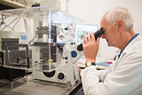 Biochemist using large microscope and computer
