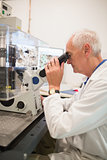 Biochemist using large microscope and computer