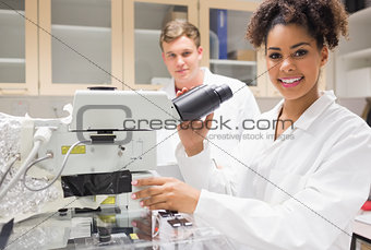 Pretty science student using microscope