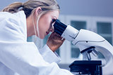 Science student looking through microscope in the lab