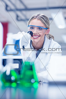 Happy science student working with microscope in the lab