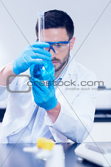 Science student looking at beaker