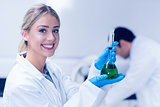 Science student holding green chemical in beaker